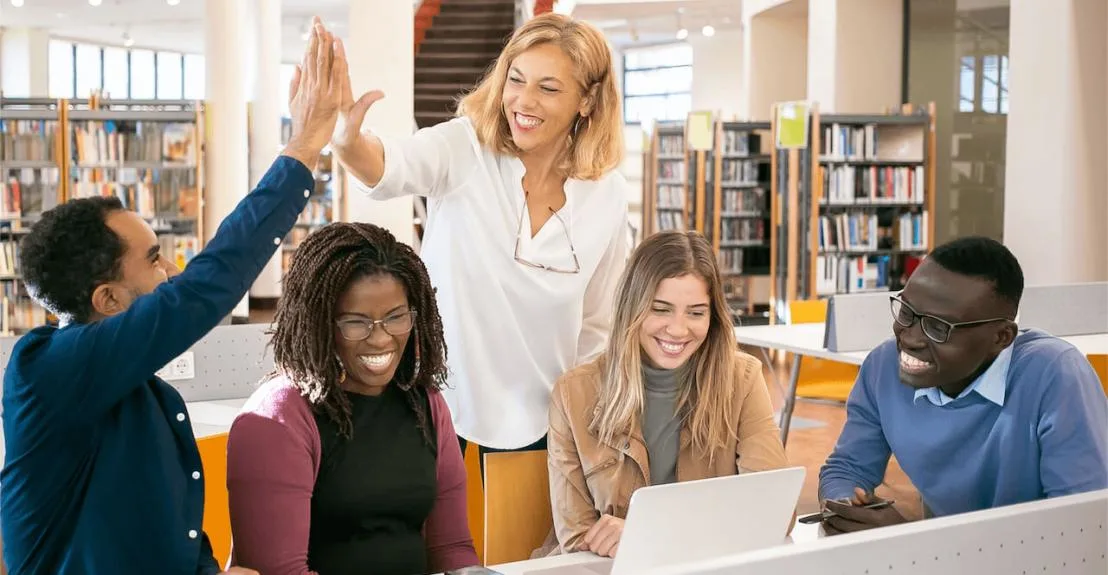 teacher in library helping students